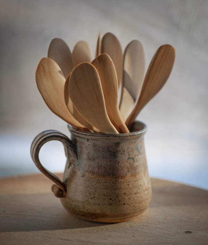 Collection of butter knives in a ceramic cup